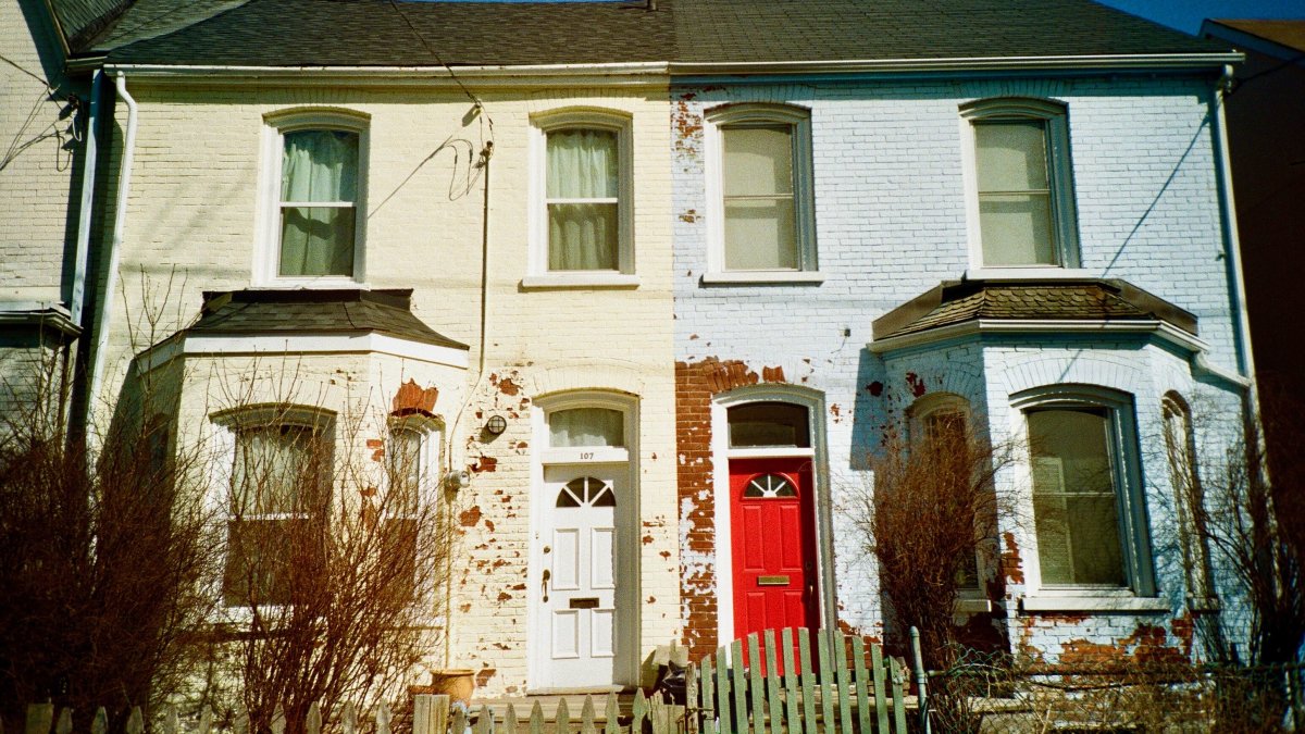 Colonial-style brick houses with rustic charm featuring distinct red and white doors